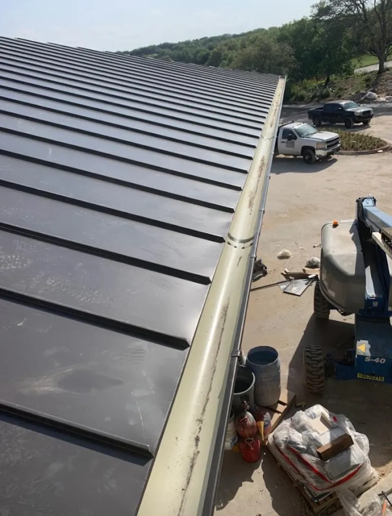 Standing seam panel and gutter detail on a metal roofing jobsite in Heber